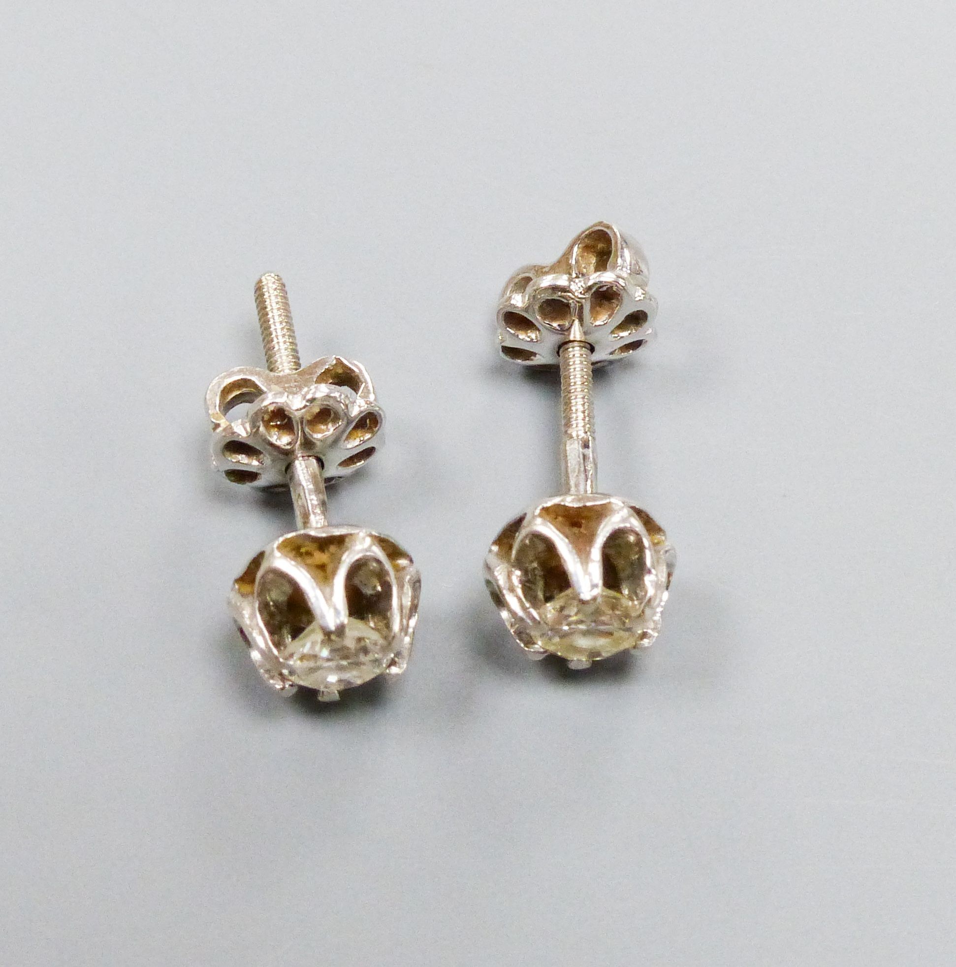 A pair of white metal and solitaire diamond set ear studs, each stone approx. 0.20ct, gross weight 2.4 grams.